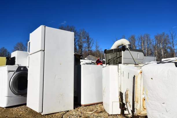 An image of several old appliances at a recycling facility.